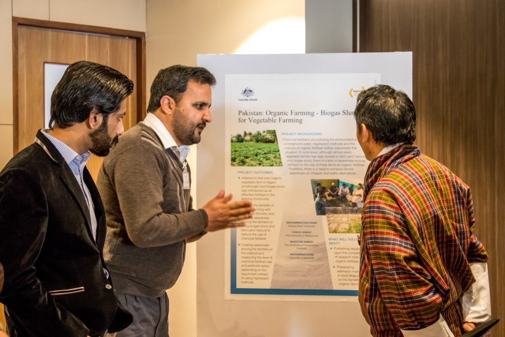 Riaz (second from left) presenting his work to Dasho Karma Tshiteem (right), a distinguished public servant in Bhutan, during the 2018 Regional Alumni Workshop in Thimphu.