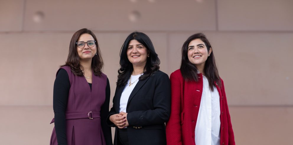 Three Pakistani Australia Awards alumnae stand together outdoors